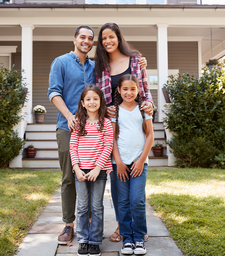 Happy family standing in front of pest-free home.